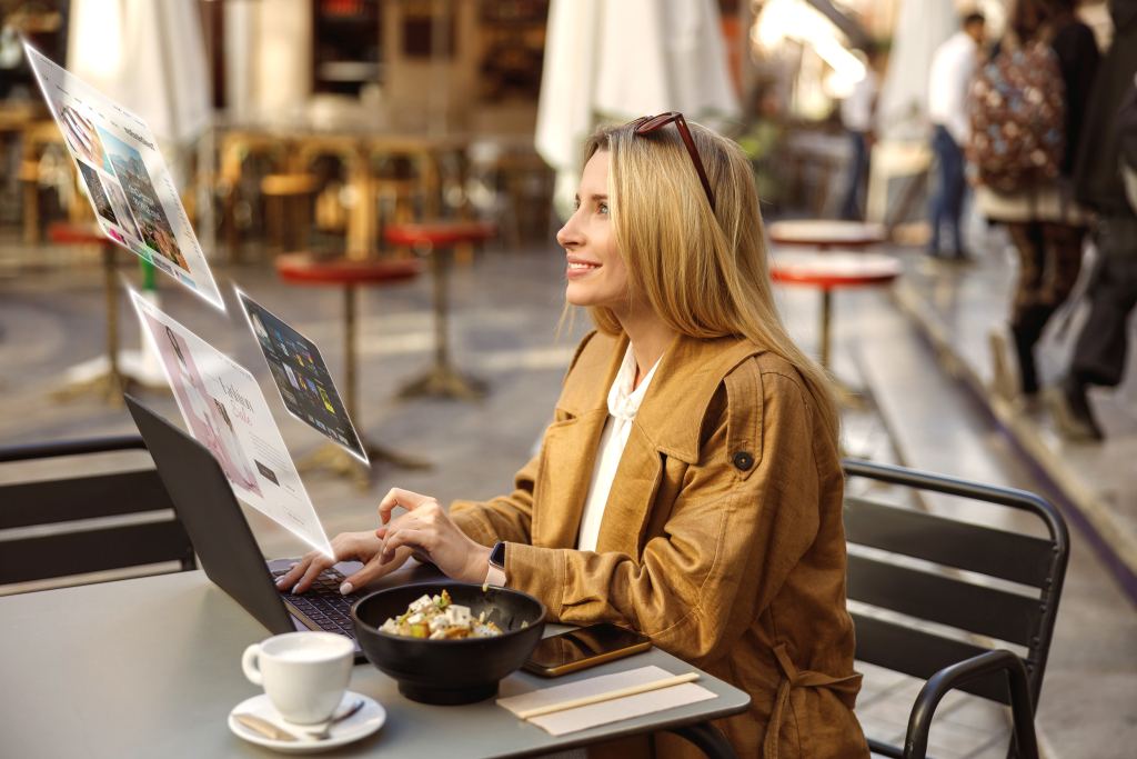 A happy café customer using a laptop and smartphone connected to fast Wi-Fi.