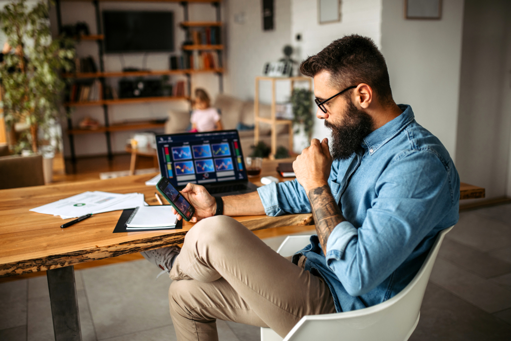 A man working from home in a stylish workspace featuring a laptop.