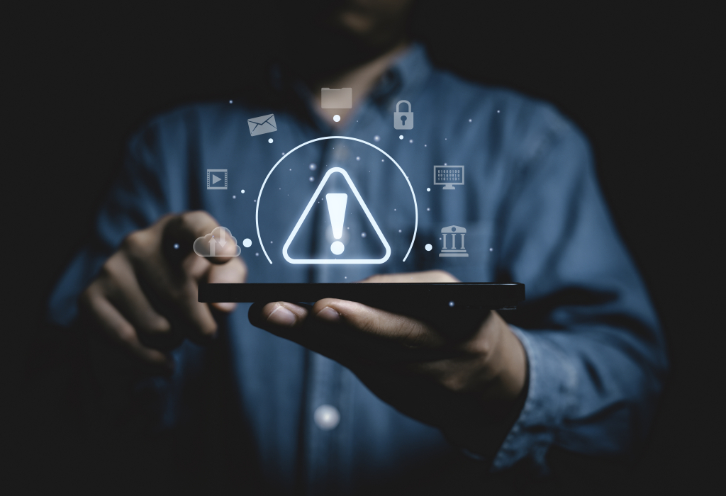 Illustration of a digital triangle caution sign surrounded by various devices connections like smartphones, laptops, and smart home gadgets.