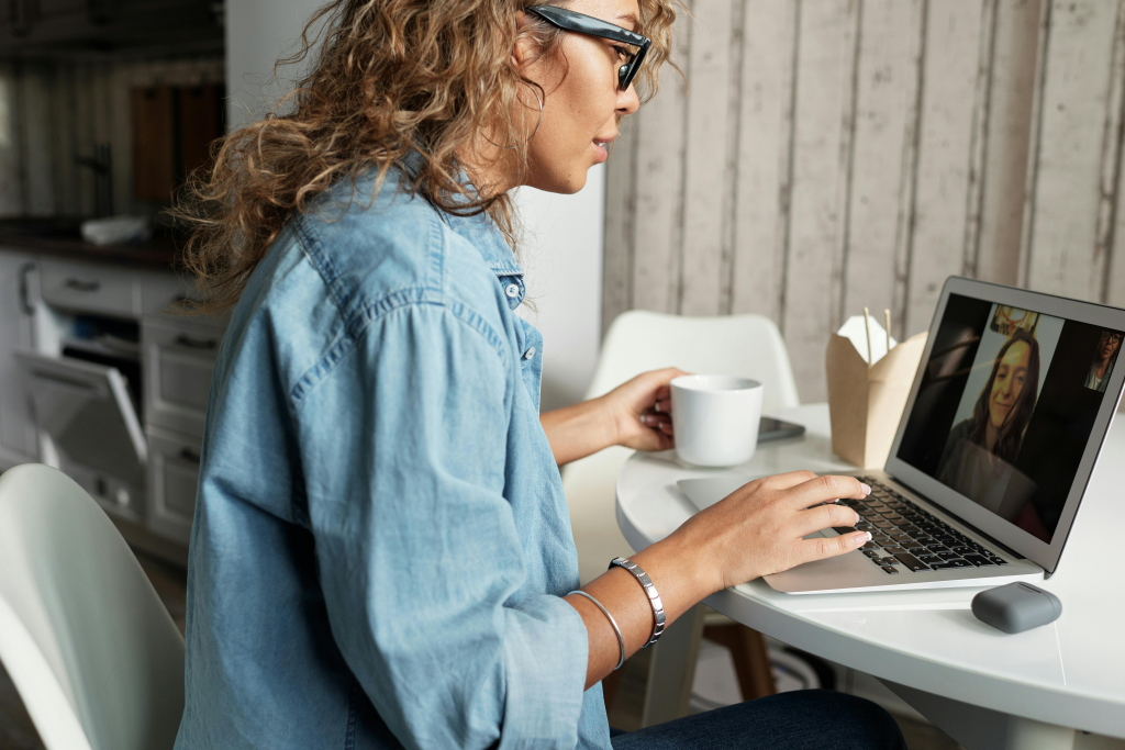 A business owner in a cozy, well-lit office on a video call on a laptop with a relieved expression, symbolizing stress-free connectivity.